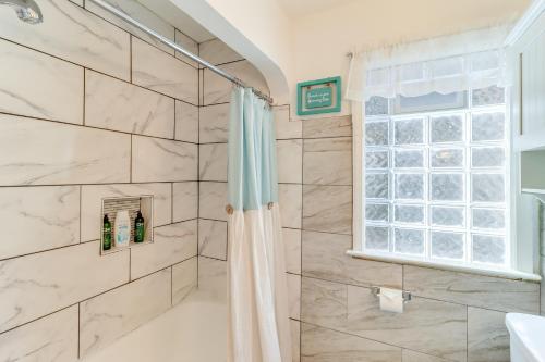 a bathroom with a shower and a window at Peaceful Detroit Home 10 Mi to Downtown! in Detroit
