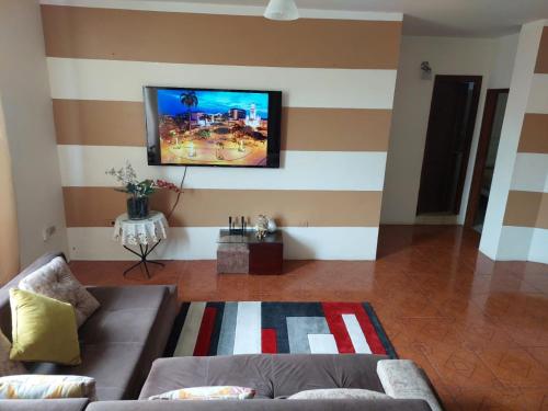 a living room with a couch and a flat screen tv at Departamentos de la Costa3 in Machala