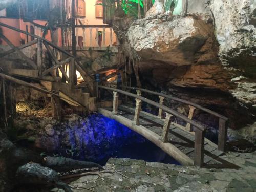- un pont en bois sur une piscine d'eau dans une grotte dans l'établissement HDA VALENTINA, à Playa del Carmen