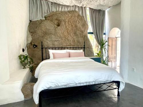 een slaapkamer met een bed met een grote rots bij Rosarii Pacis Villa - Venuestay in Thôn Bình Hưng