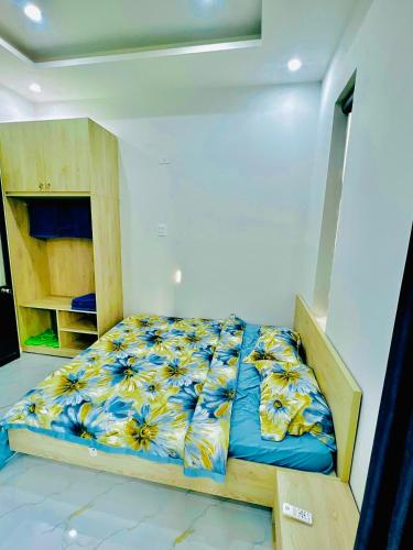 1 dormitorio con 1 cama con manta azul y amarilla en Villa Quy Nhơn Gần Biển Gần Trung Tâm - Biệt Thự Quy Nhơn Gần Biển, en Quy Nhon
