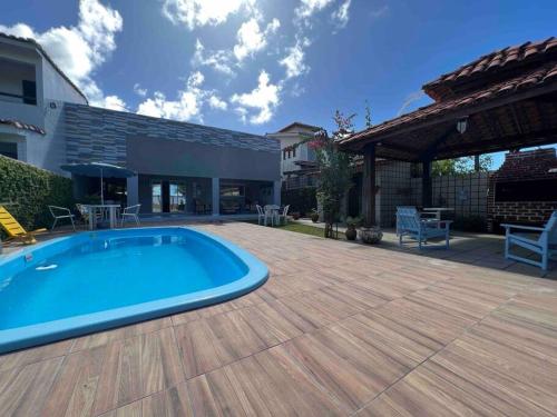 einen Hinterhof mit einem Pool und einer Holzterrasse in der Unterkunft Casa Itamaracá in Itamaracá