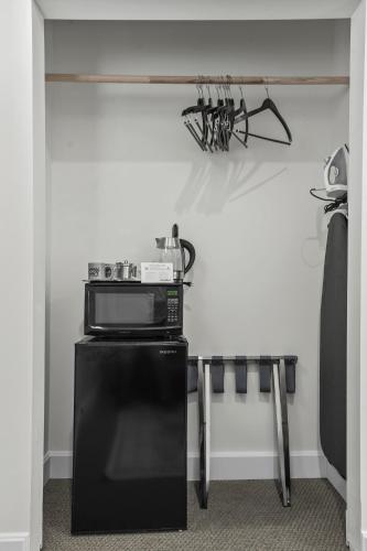 a microwave sitting on top of a refrigerator in a room at Club Hotel in Idaho Springs