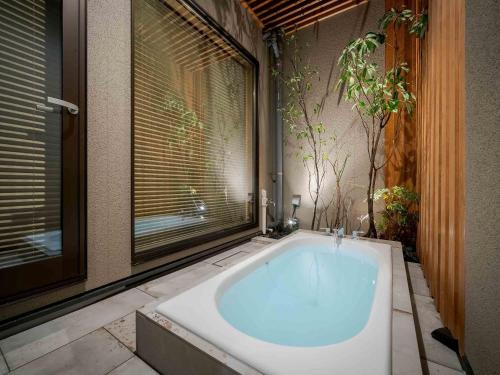 a large bath tub in a bathroom with a window at Tokikaze Machiya House in Kanazawa