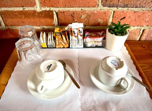 una mesa con dos tazas y platos en una mesa en Diamond House Heritage Restaurant and Motor Inn, en Stawell