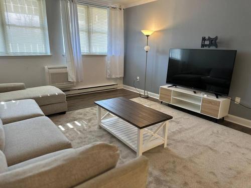 a living room with a large flat screen tv at Cozy 1BR Condo in West Hartford