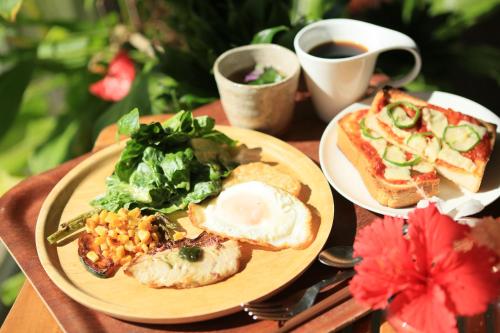 stół z dwoma talerzami jedzenia i filiżanką kawy w obiekcie Nata Beach Villa w mieście Ishigaki