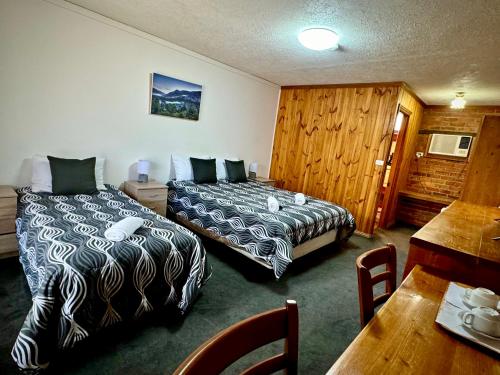 Habitación de hotel con 2 camas y mesa en Diamond House Heritage Restaurant and Motor Inn, en Stawell