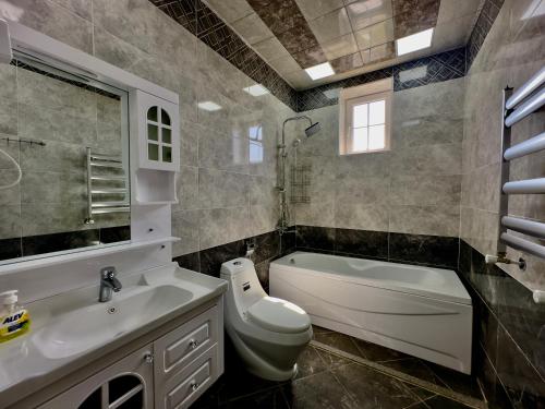 a bathroom with a sink and a toilet and a tub at Gabala Modern Harmony in Gabala