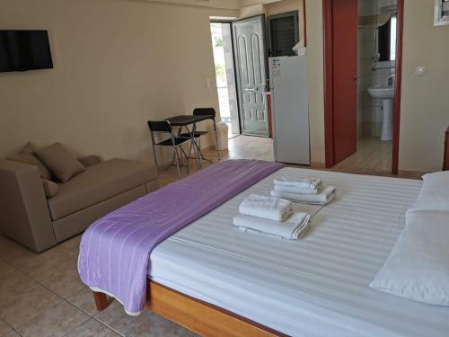 a bedroom with a bed with towels on it at Nefeli Apartments in Stoupa