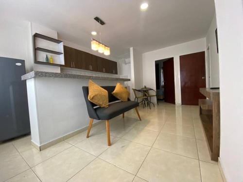 a living room with a chair and a kitchen at Apartamento en Bucaramanga in Bucaramanga