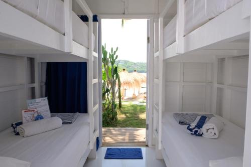 2 weiße Etagenbetten in einem Zimmer mit Aussicht in der Unterkunft Le Pirate Beach Club Nusa Ceningan - Adults Only in Nusa Lembongan