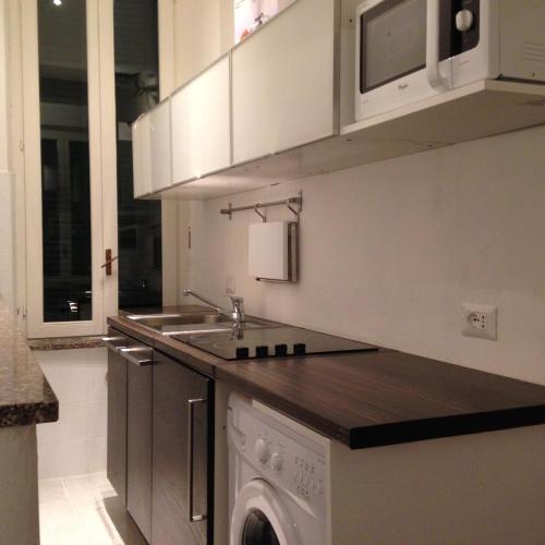 a kitchen with a sink and a washing machine at Como Studio Flat in Como