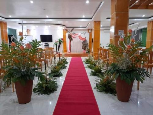 a aisle with a red carpet in a room with chairs at Cherry's CourtYard in Puerto Princesa City