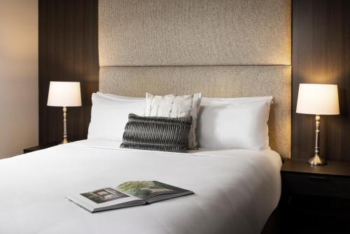 a hotel room with a bed with a book on it at Mineral Springs Hotel Hepburn in Hepburn Springs