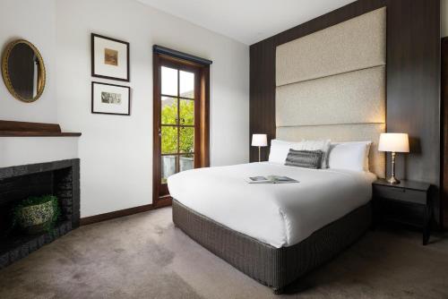 a bedroom with a large bed and a fireplace at Mineral Springs Hotel Hepburn in Hepburn Springs