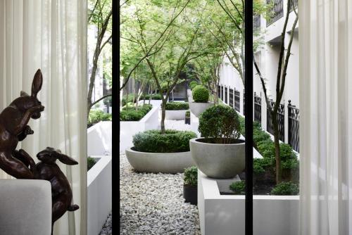 a hallway with a courtyard with trees and bushes at The Lyall in Melbourne