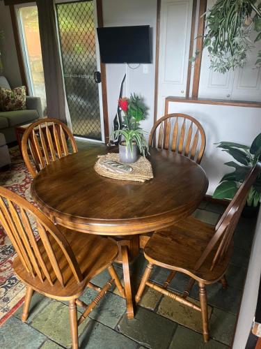 a wooden table with two chairs and a table with flowers on it at Whitsundays BNB Retreat in Airlie Beach