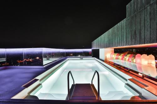 una piscina con un banco en un edificio en T24 Residency en Bombay