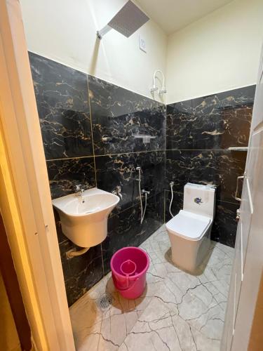 ein Badezimmer mit einem Waschbecken, einem WC und einem Waschbecken in der Unterkunft Km mansion in Chennai
