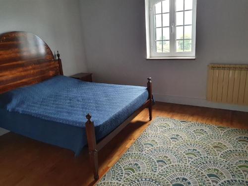 una camera da letto con un letto con un piumone blu e una finestra di Ferienhaus für 20 Personen in Ribeiradio, Regio Centro Beira a Ribeiradio