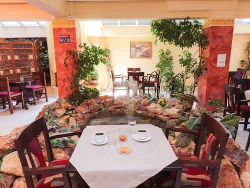 une table et des chaises dans un restaurant avec un mur en pierre dans l'établissement Spa Hotel Alex, à Loutra Edipsou