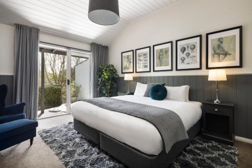 a bedroom with a large bed and a blue chair at Mineral Springs Hotel Hepburn in Hepburn Springs