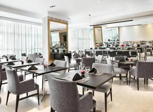 un comedor con mesas y sillas en un restaurante en Hotel M-LIÁ Jd Europa - Itaim BiBi - Classic Deluxe Duplex Studio - Executive Edition - By LuXXoR en São Paulo