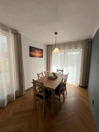 a dining room with a wooden table and chairs at Slunečný apartmán Velké Losiny in Velké Losiny