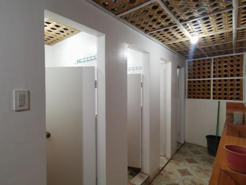 a room with white walls and a wall with white doors at Tambayan Rooms and Cottages by SMS Hospitality in Carmen