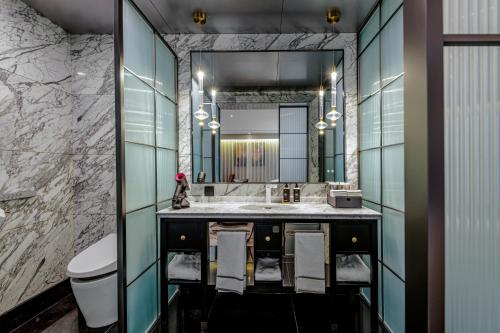a bathroom with a sink and a large mirror at UrCove by Hyatt Beijing Guomao Sanlitun in Beijing