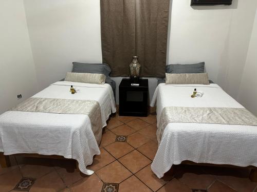 two beds sitting next to each other in a room at house with pool yucatan in Ucú