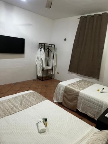 a room with two beds and a flat screen tv at house with pool yucatan in Ucú