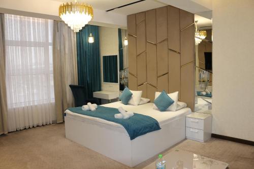 een slaapkamer met een bed met twee knuffels erop bij Hotel Tajikgrey Dushanbe in Doesjanbe