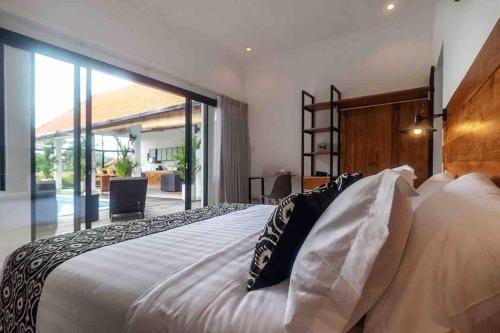 ein Schlafzimmer mit einem großen weißen Bett mit Kissen in der Unterkunft New 3BR villa,Sunset &ricefield views Canggu area! in Kerobokan