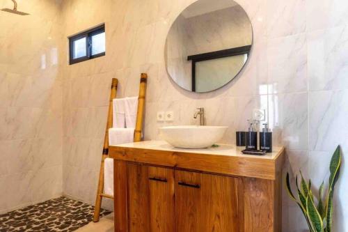 ein Bad mit einem Waschbecken und einem Spiegel in der Unterkunft New 3BR villa,Sunset &ricefield views Canggu area! in Kerobokan