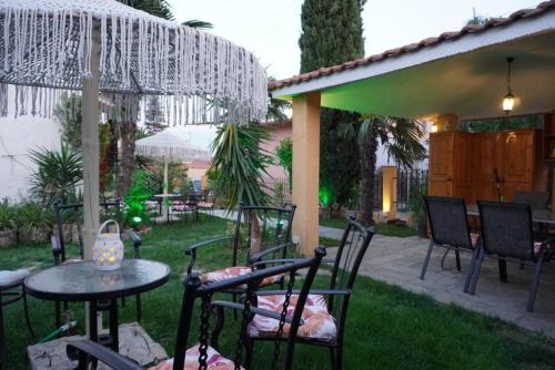 a patio with chairs and a table in the grass at Villa Vaso with jacuzzi in Epanomi
