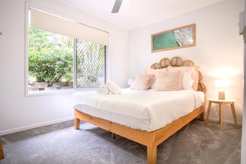 a bedroom with a large bed and a window at Pet Friendly Battery Hill Home away from Home in Caloundra