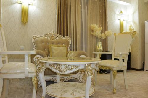 ドゥシャンベにあるHotel Tajikgrey Dushanbeのテーブルと椅子2脚のあるリビングルーム