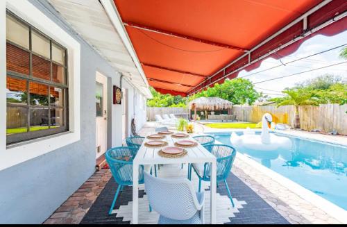 a white table and chairs next to a swimming pool at Philllips Tropical Paradise in Fort Lauderdale