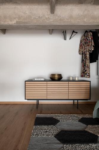 a living room with a dresser against a white wall at Super stylish loft in Tallinn