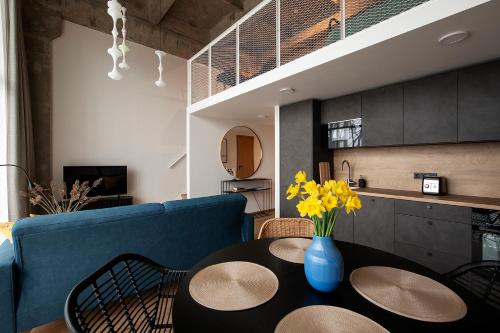 a living room with a table and a blue couch at Super stylish loft in Tallinn