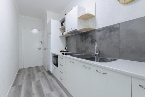 una cucina con mobili bianchi e un lavandino di 1 Bedroom @ Palm Villas #22 a Port Douglas