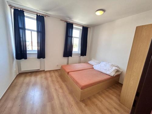 Habitación con 1 cama en una habitación con 2 ventanas en Ubytovna Dolní Dunajovice en Dolní Dunajovice
