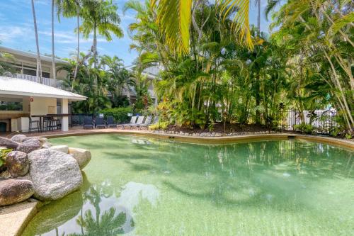 una piscina in un resort con palme di 1 Bedroom @ Palm Villas #22 a Port Douglas