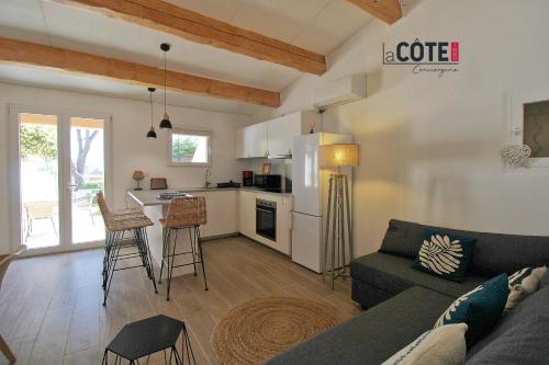 un salon avec un canapé et une cuisine dans l'établissement A CASELLA - 4 Couchages, à Sausset-les-Pins