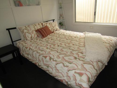 a bedroom with a bed with a comforter on it at Retreat on Talbot in Port Vincent