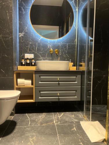 a bathroom with a sink and a mirror at Apartament Old Town Bednarska 22 in Elblag