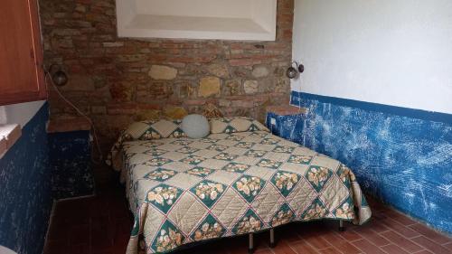 BinamiにあるLa Pievacciaのレンガの壁にベッド1台が備わるベッドルーム1室