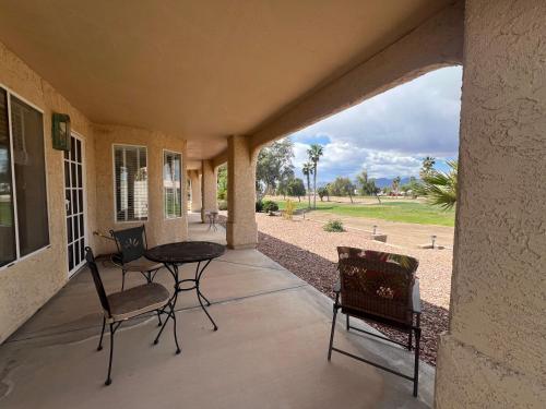 a patio with a table and chairs on a porch at Sunset Oasis in Fort Mohave